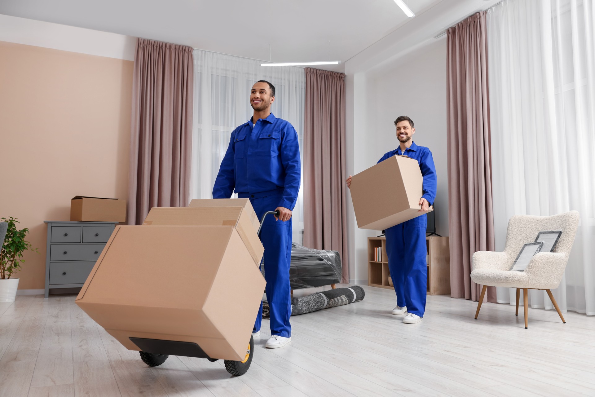 Male movers with cardboard boxes in new house